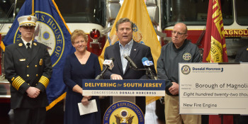 Congressman Norcross speaks to the media in front of fire trucks, local officials, and firefighters at the Magnolia Fire Department